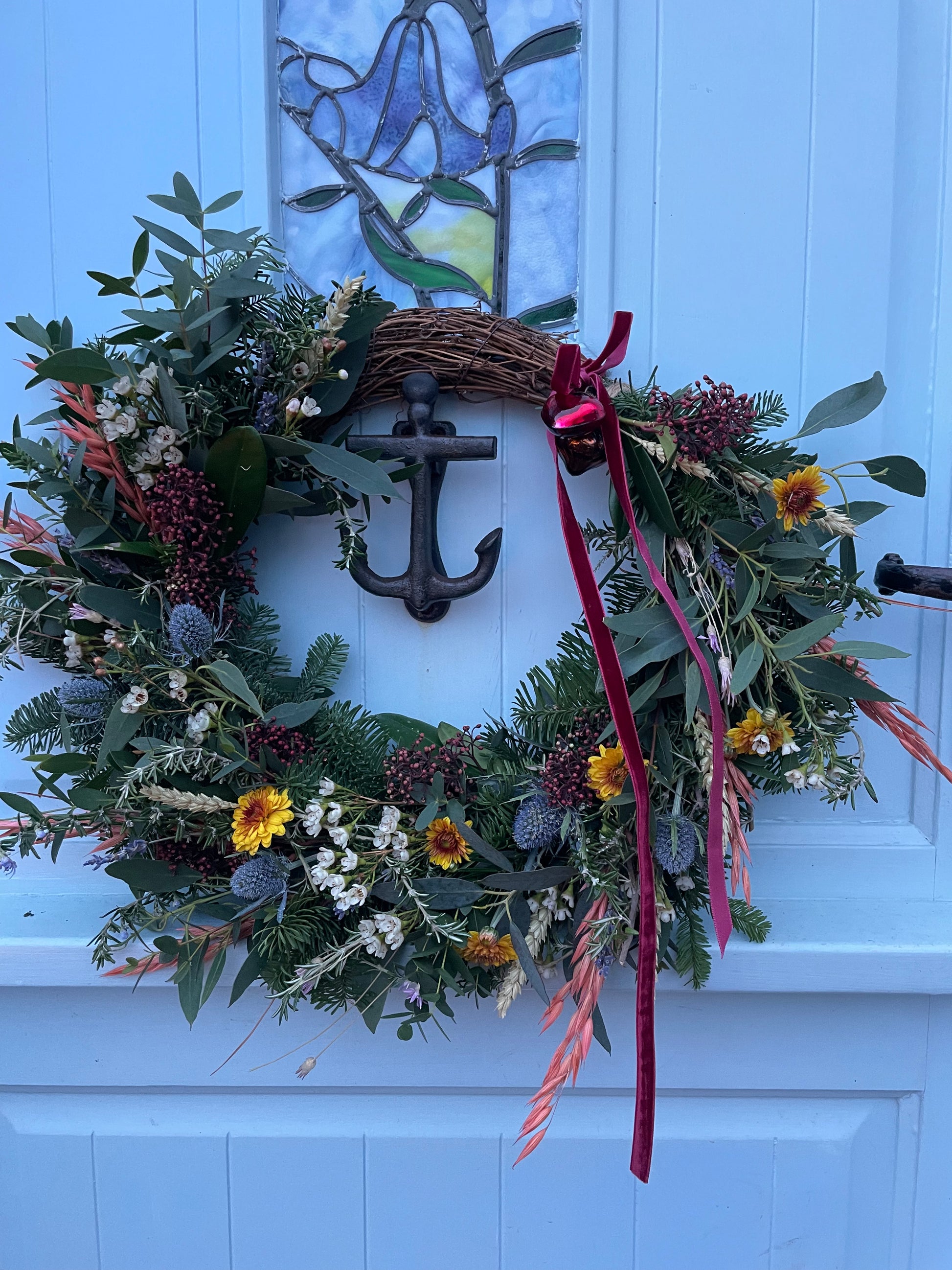 Close-up of Boscastle Cottage Wreath showing rosemary, sea holly, and velvet ribbon – Barns Florals Cornwall.