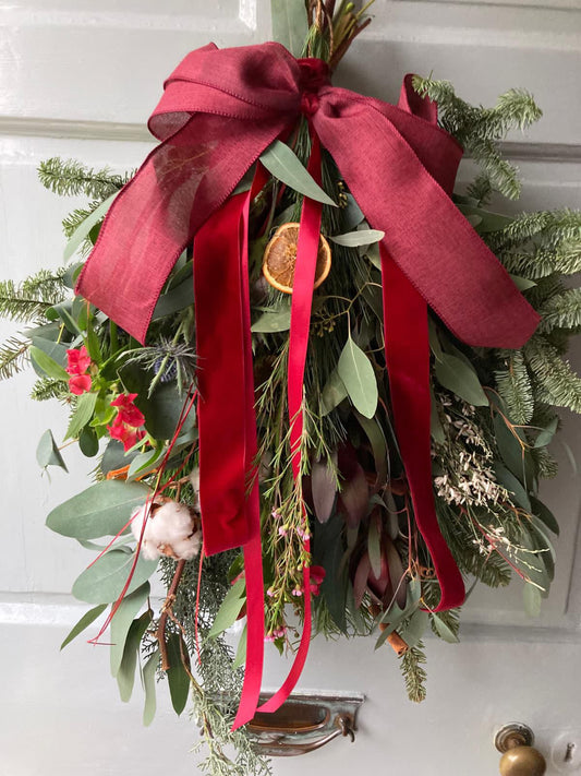Close-up of Christmas swag showing pinecones, dried oranges, and cinnamon sticks – Barns Florals