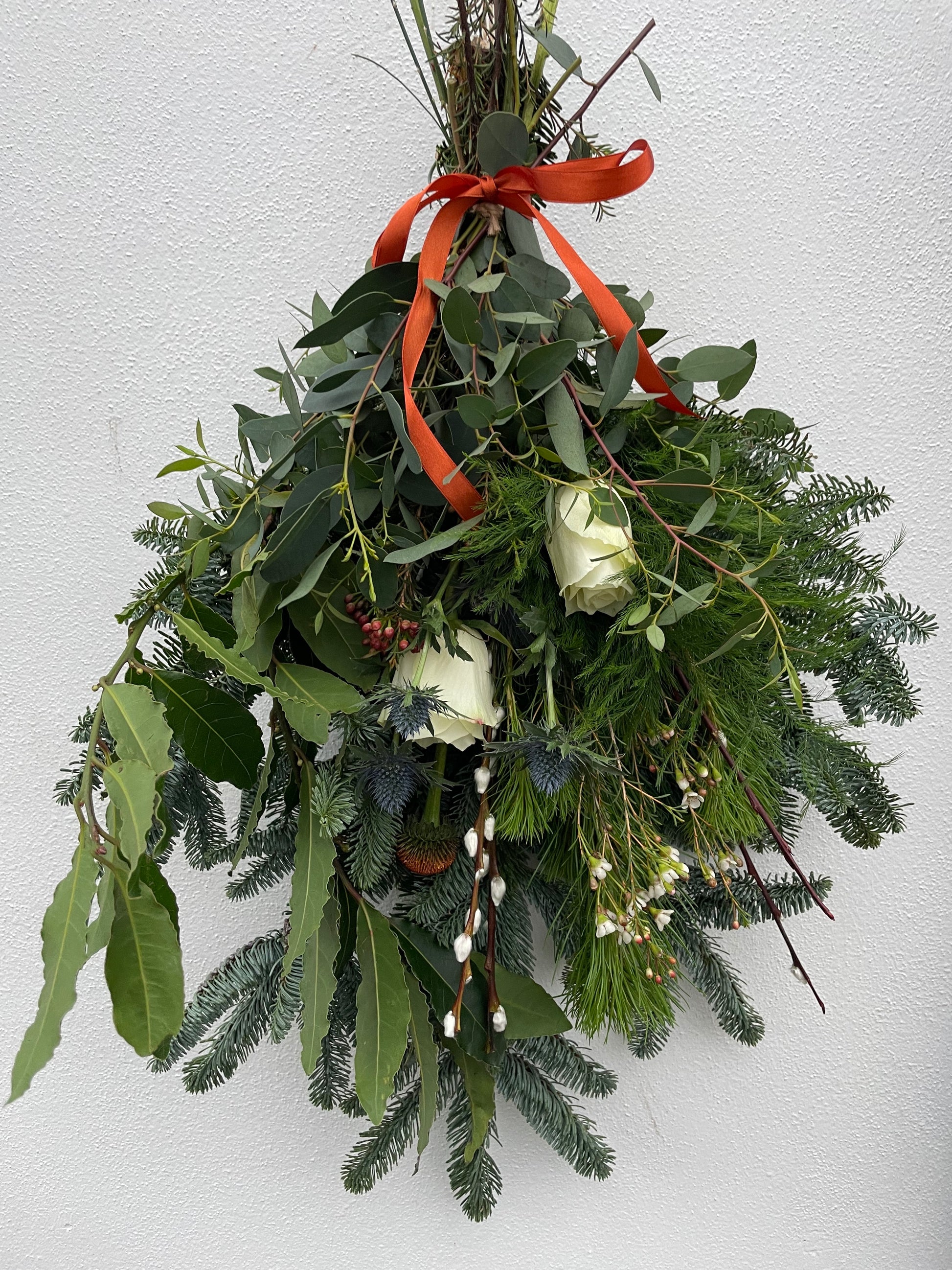 Natural Christmas swag hanging on a front door – handmade in Cornwall by Barns Florals.