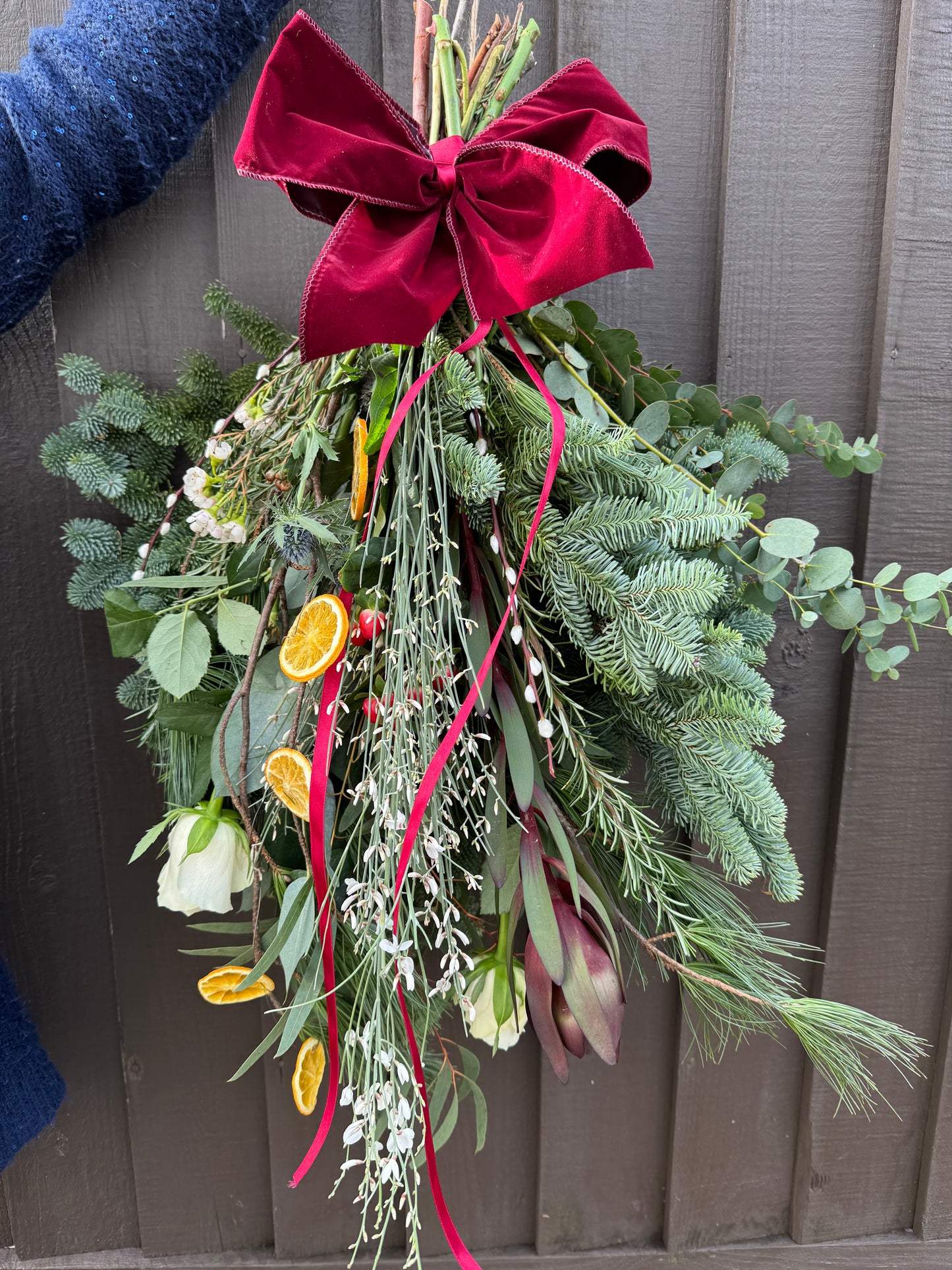 Handmade Christmas door swag with spruce, eucalyptus, and velvet ribbon – Barns Florals
