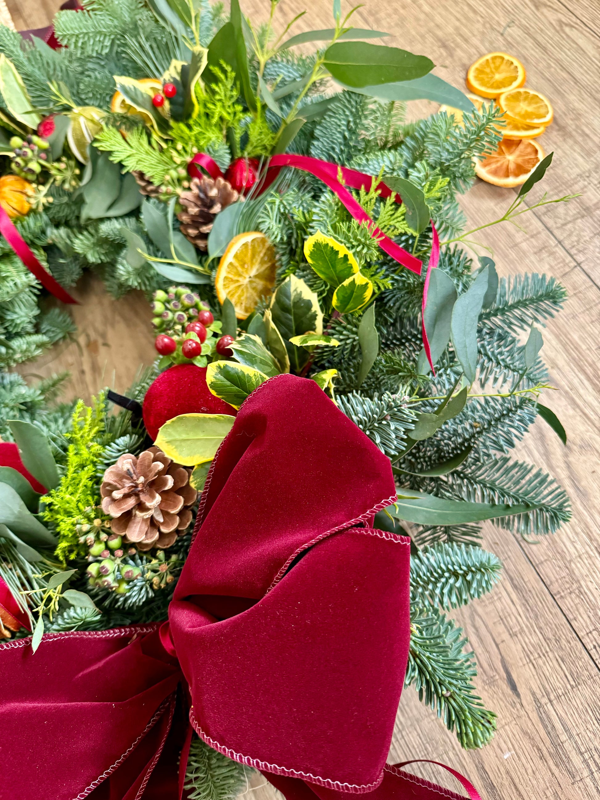 Luxury fresh and dried Christmas wreath with layered foliage and velvet ribbon – Barns Florals Cornwall.