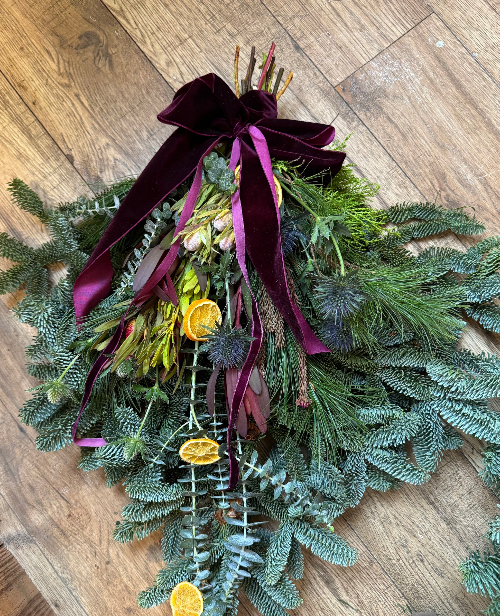 Spruce and eucalyptus foliage swag with layered texture and velvet ribbon